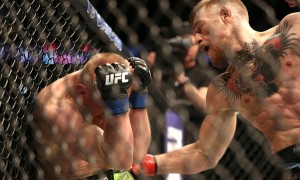 Conor McGregor, of Ireland, left, iands a right to the body against Dennis Siver, of Germany, during their featherweight fight at UFC Fight Night, Sunday, Jan. 18, 2015 in Boston.  McGregor won via 2nd round TKO. (AP Photo/Gregory Payan)